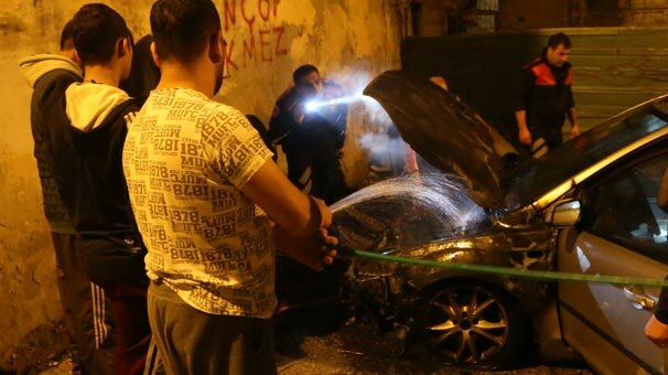 Yanan aracına hortumla müdahale etti